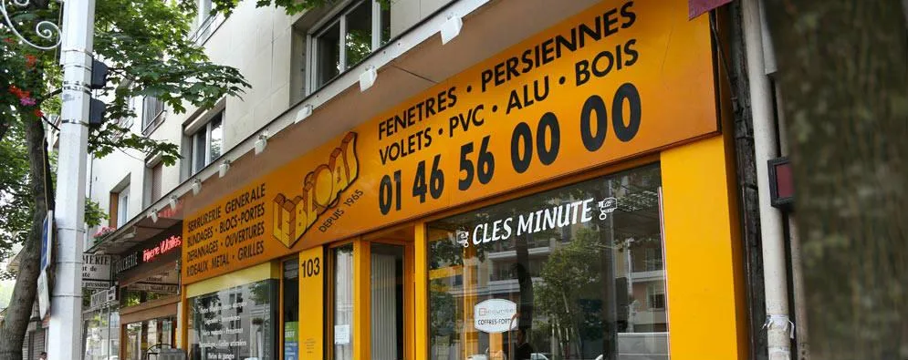 La devanture jaune de la serrurerie Le Bloas, au 103 rue Gabriel Péri à Montrouge, avec son numéro de téléphone en grandes lettres noires
